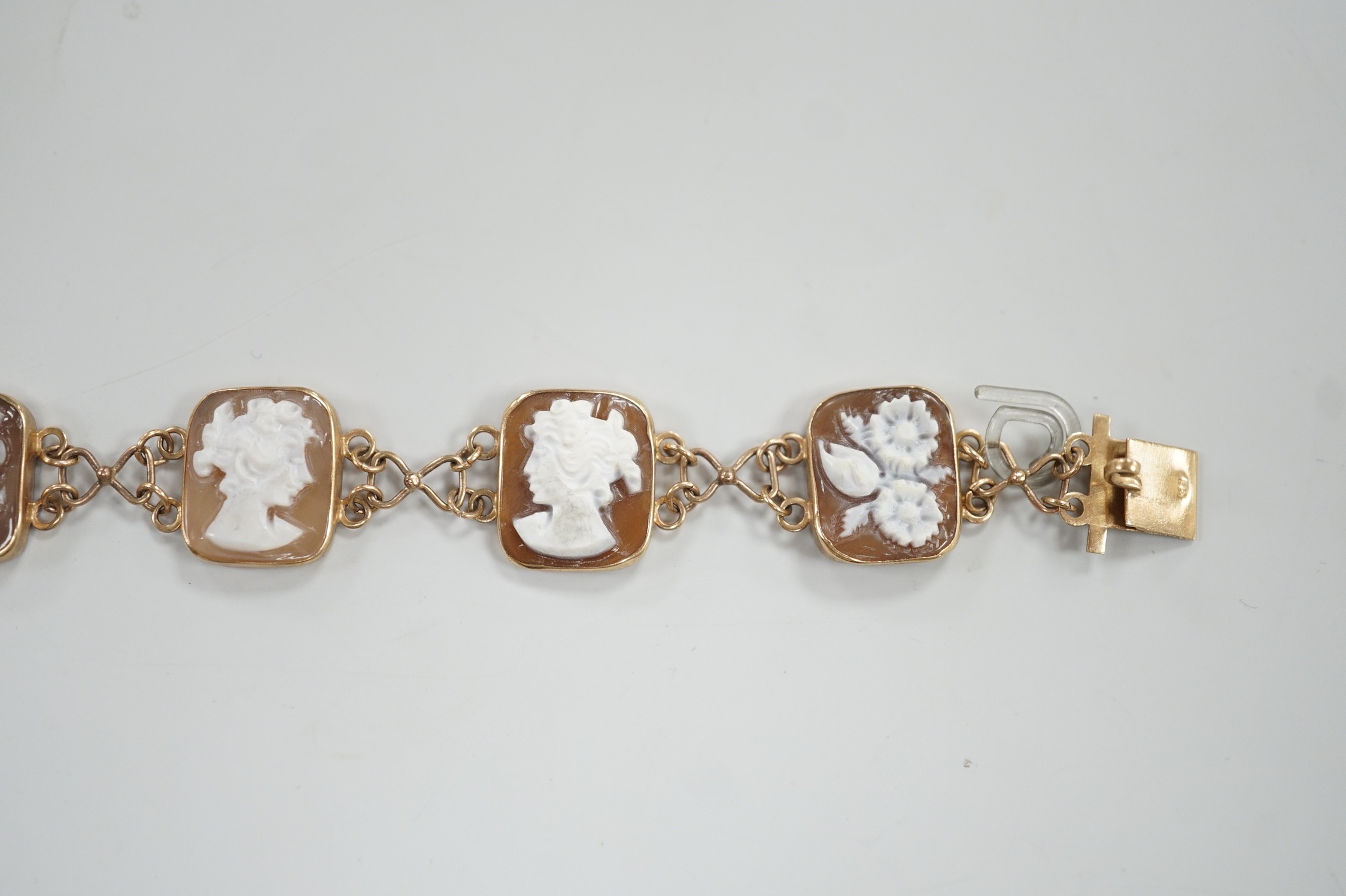 A 1970's 9ct gold and seven cameo panel set bracelet, carved with busts of ladies or flowers, 18cm, gross weight 10.3 grams.